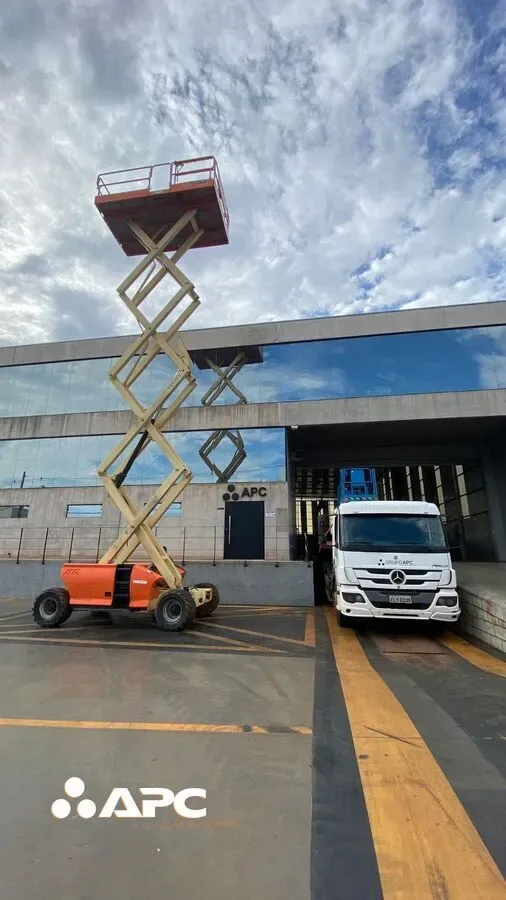 Plataformas Elevatórias de Tesoura (Pantográfica) da marca JLG. A plataforma estyá em frente a empresa de fachada de vidro.